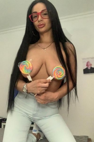 Ernesta is wearing glasses and covering her boobs with lollipops 