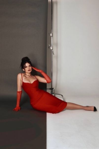 Reagan is sitting on the floor in a long red dress 