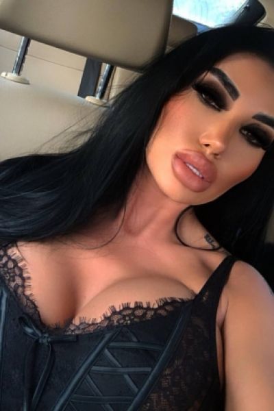 Busty brunette lady sitting in a car