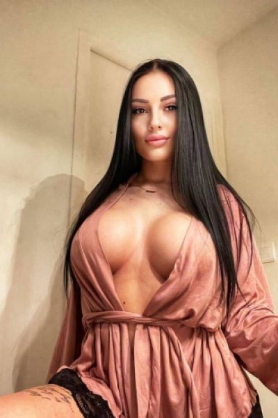 Busty brunette escort Karson is wearing a very revealing top 