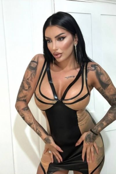 Mistress Daria is standing with her hands on her hips 