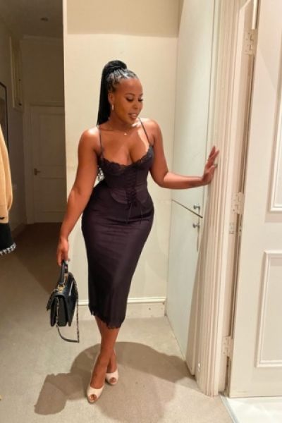 A selfie of a black Pune escort lady in a black dress 